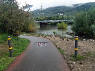 Foto della pista ciclabile lungo il Bisenzio con cartello di divieto di accesso per possibili allagamenti