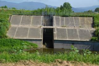 Dettaglio della portella di resa della cassa di espansione, fotografata dall\'argine del fiume.