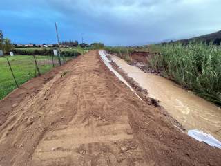 Pista ciclabile completamente coperta dai detriti del fiume che scorre a fianco.