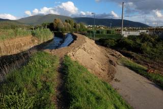 Terreno franato sulla pista ciclabile, ricoperta da terra e fango.