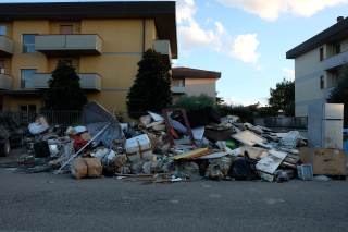 Vari rifiuti ammucchiati fuori dalle abitazioni colpite dall\'alluvione.