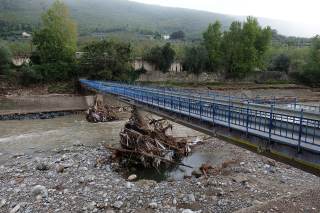 Ponte blu con detriti rimasti attaccati ai piloni del ponte e ringhiera divelta