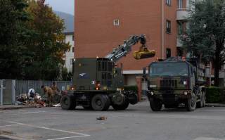 Militari mentre tolgono rifiuti alluvionati dalle strade con i mezzi pesanti